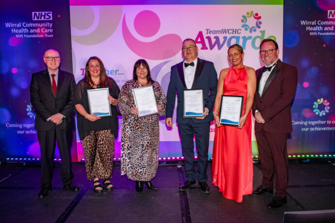 Staff with their Long service award certificates on stage