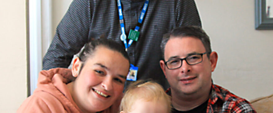 Health Visitor and little girl who is sat with her Mum and Da